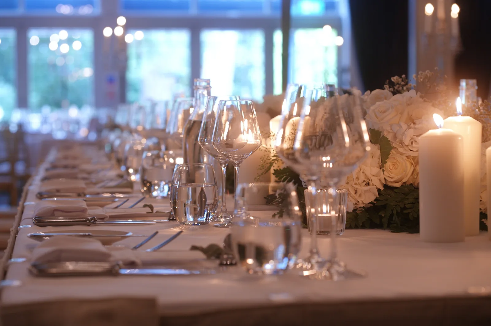 A long candlelit banquet table at Kilkea Castle set with glassware and white flowers
